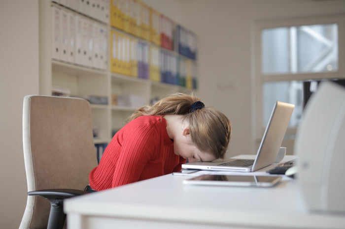 A woman in pain while sitting on a chair at work