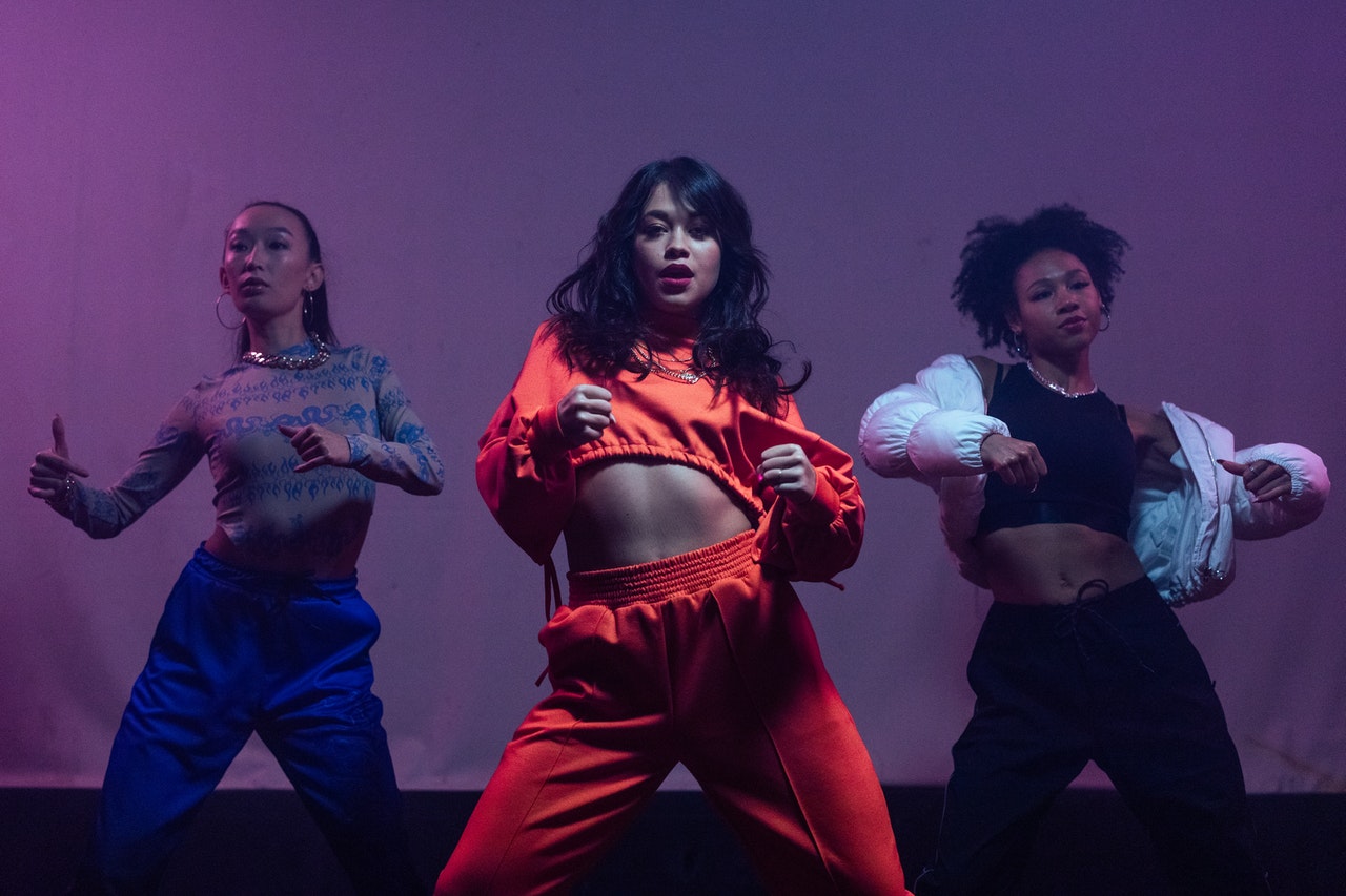 Women in  hip-hop outfits dancing together