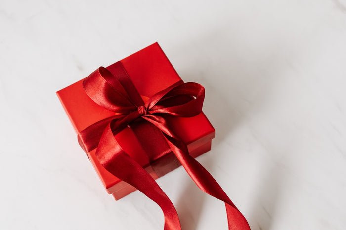A red box with a red satin ribbon