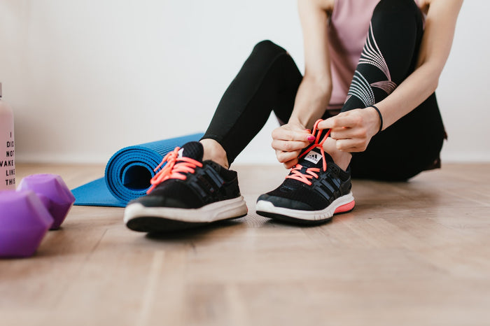 Girl doing stretching exercises at home while sitting on the floor