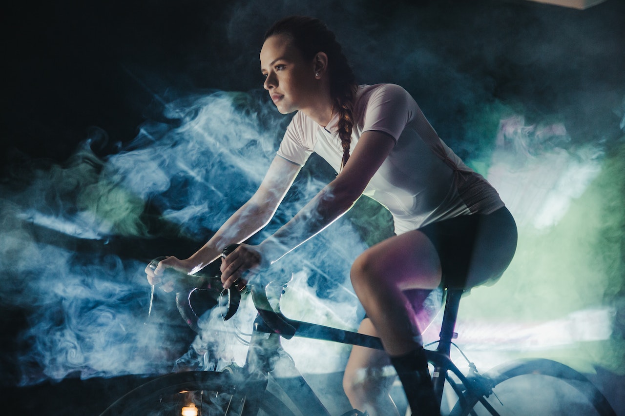 A female athlete on a bike and wearing activewear